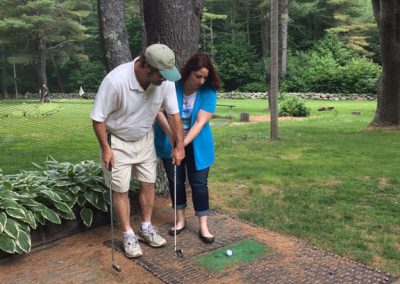 woman gets golf help from friend
