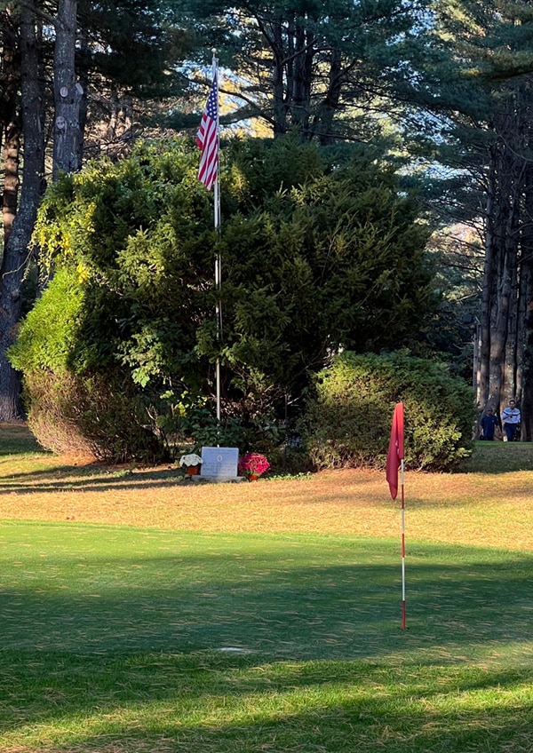 Bob L'Heureux memorial stone and flag on golf course