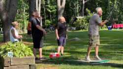 Player tees off while 3 teammates watch where the ball lands