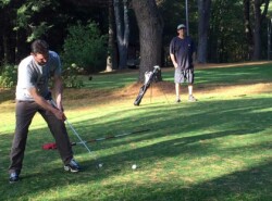 dumont putts while john looks on