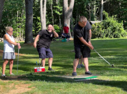Player tees off while teammate hams it up for the camera