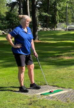 Partners Bank player stands ready to tee off listening to final tips from teammates