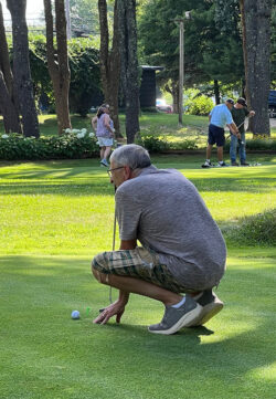 Player crouches on green lining up his putt