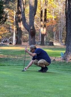 Player marks the lie of the ball on the green
