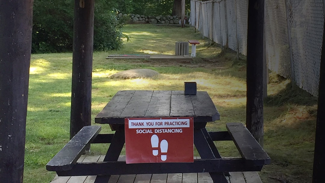 social distancing sign on picnic table area